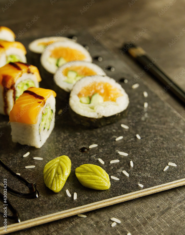 Close-up of Japanese sushi, salmon, vegetables on wooden board