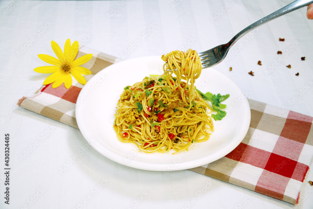 Close-up. Spicy stir-fried udon noodles. Someone will eat udon noodles with a fork.