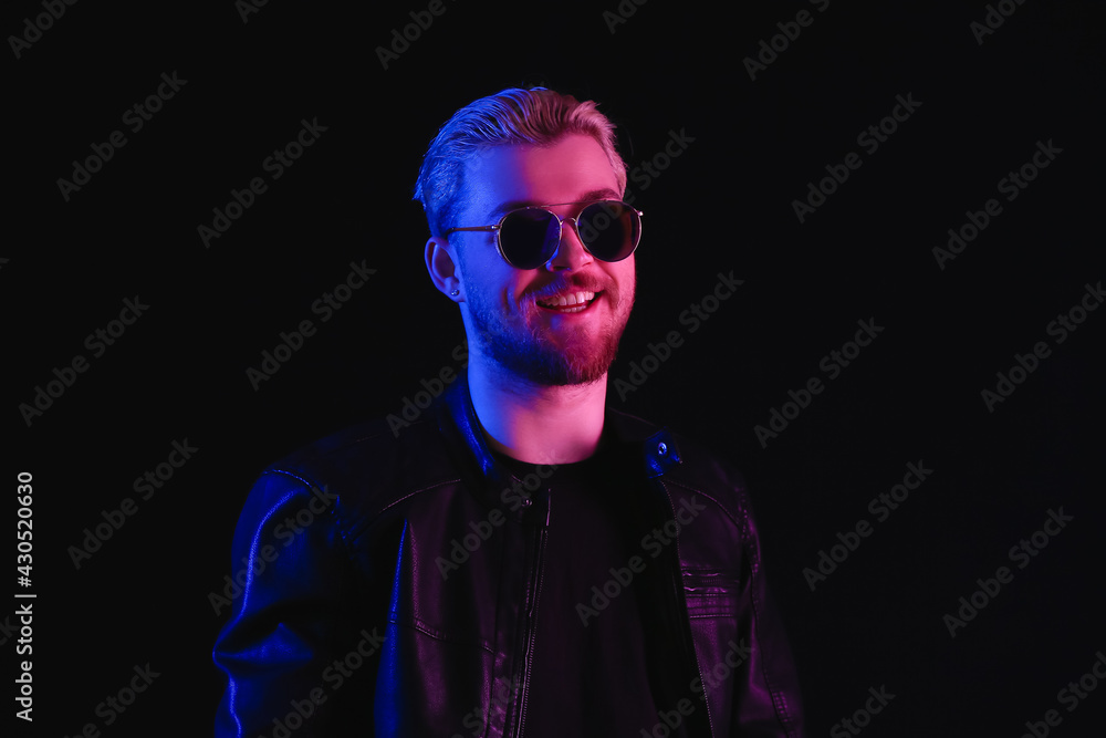 Toned portrait of handsome young man on dark background