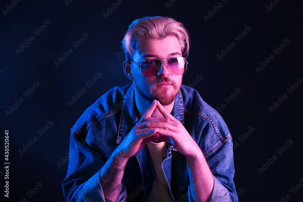 Toned portrait of handsome young man on dark background