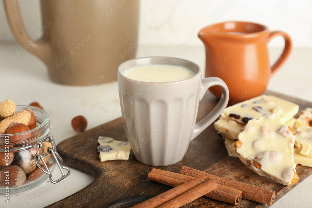 Cup with hot white chocolate on light background