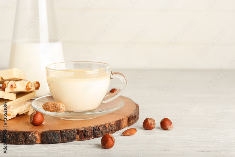 Cup with hot white chocolate on light background