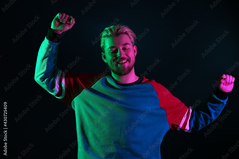 Toned portrait of handsome young man on dark background