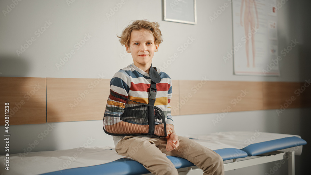 Portrait of a Healthy Young Handsome Teenage Boy Sitting on a Bench with His Hand in an Arm Brace in