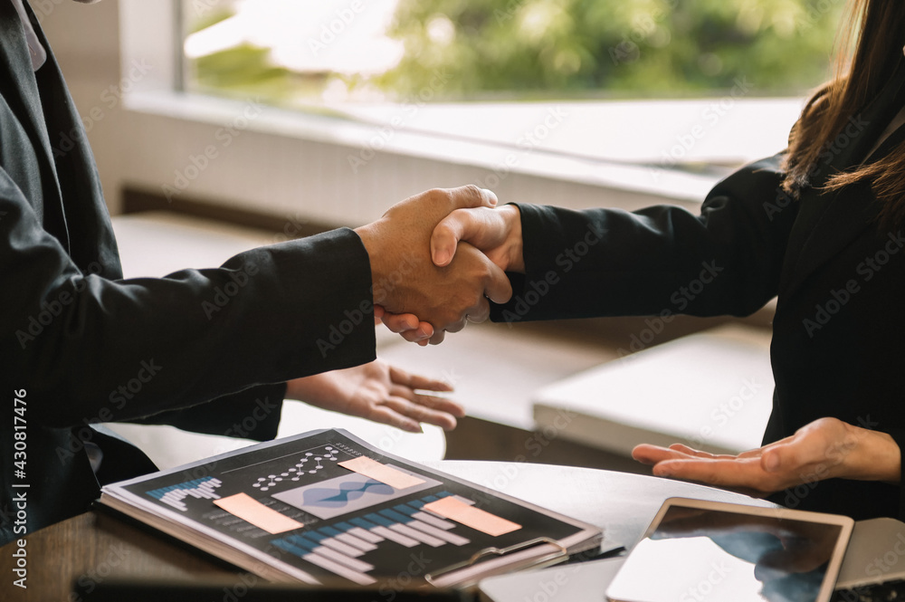 Business handshake closing a deal with blur background of people.