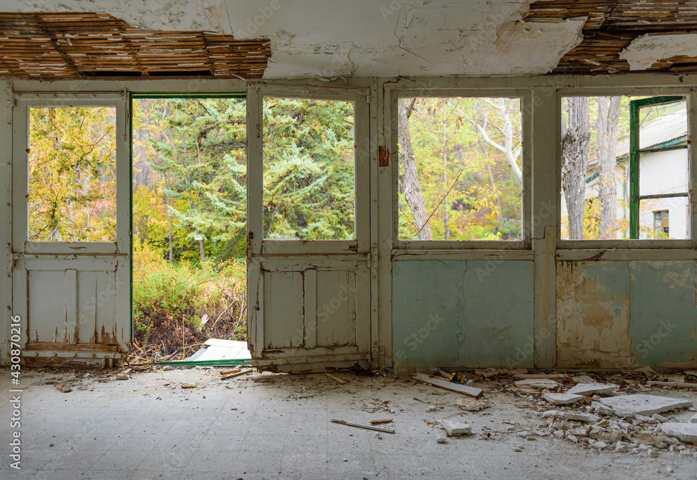 Abandoned house interior. Gallery with door and window frames, broken glass and fallen plaster, over