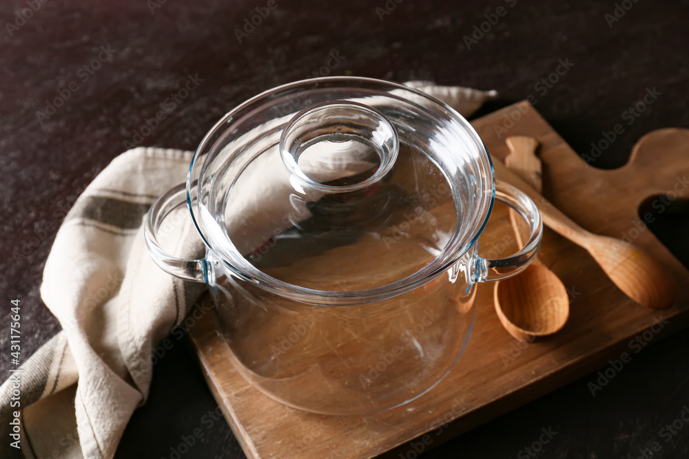 Stylish cooking pot on dark background