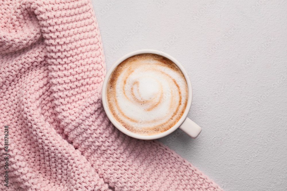 Cup of hot cappuccino on light background