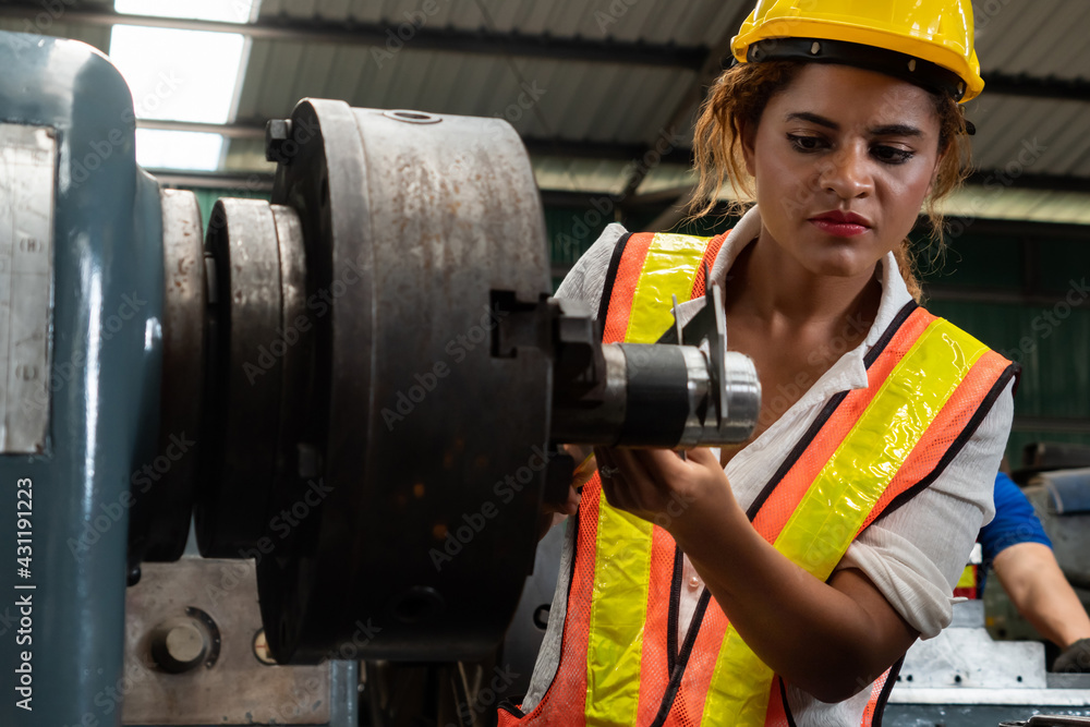 Skillful factory woman worker do machine job in manufacturing workshop . Industrial people and manuf