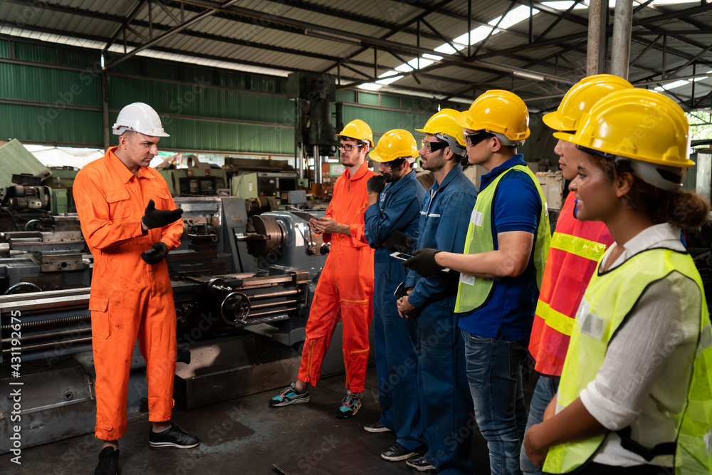 Skillful worker attending brief meeting in the factory . Industrial people and manufacturing labor c