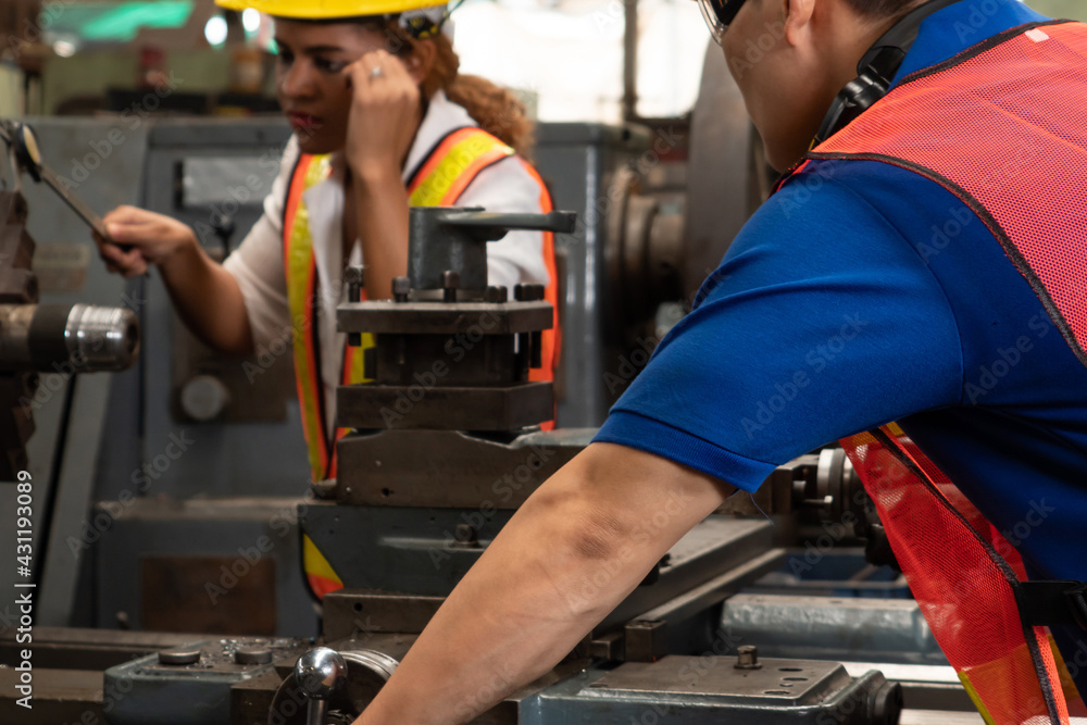 Group of skillful workers using machine equipment in factory workshop . Industry and engineering peo