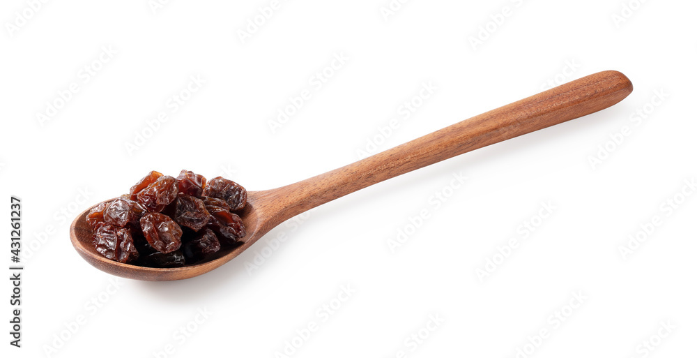 Raisins and a wooden spoon on a white background