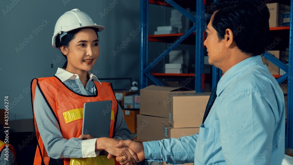 Warehouse manager and worker working in the storehouse . Logistics , supply chain and warehouse busi