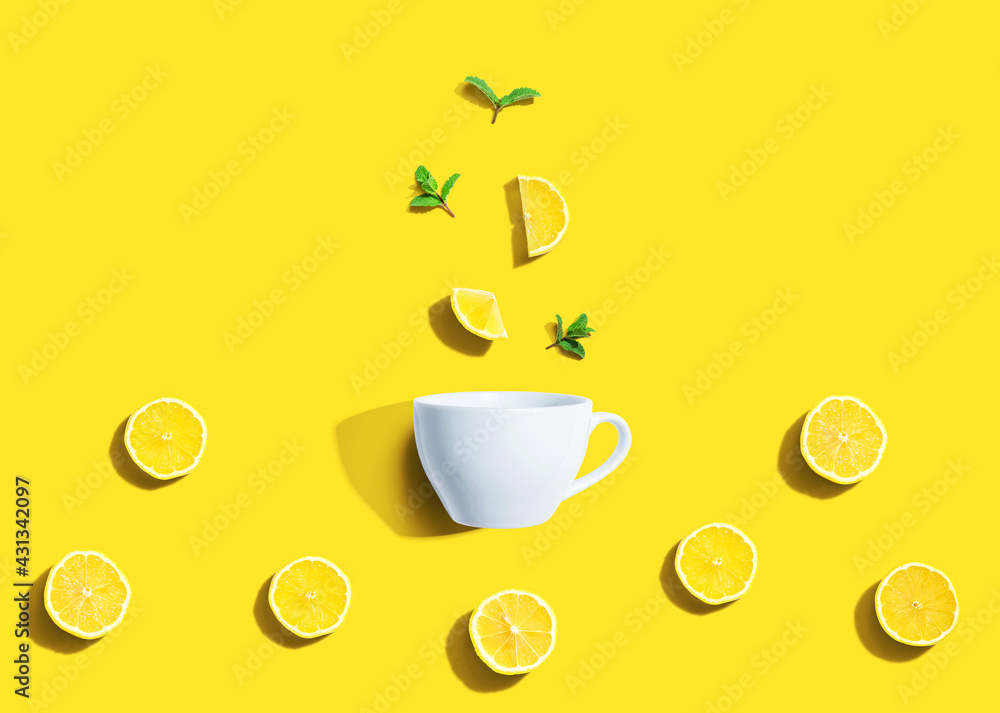 Fresh yellow lemons with tea cup overhead view