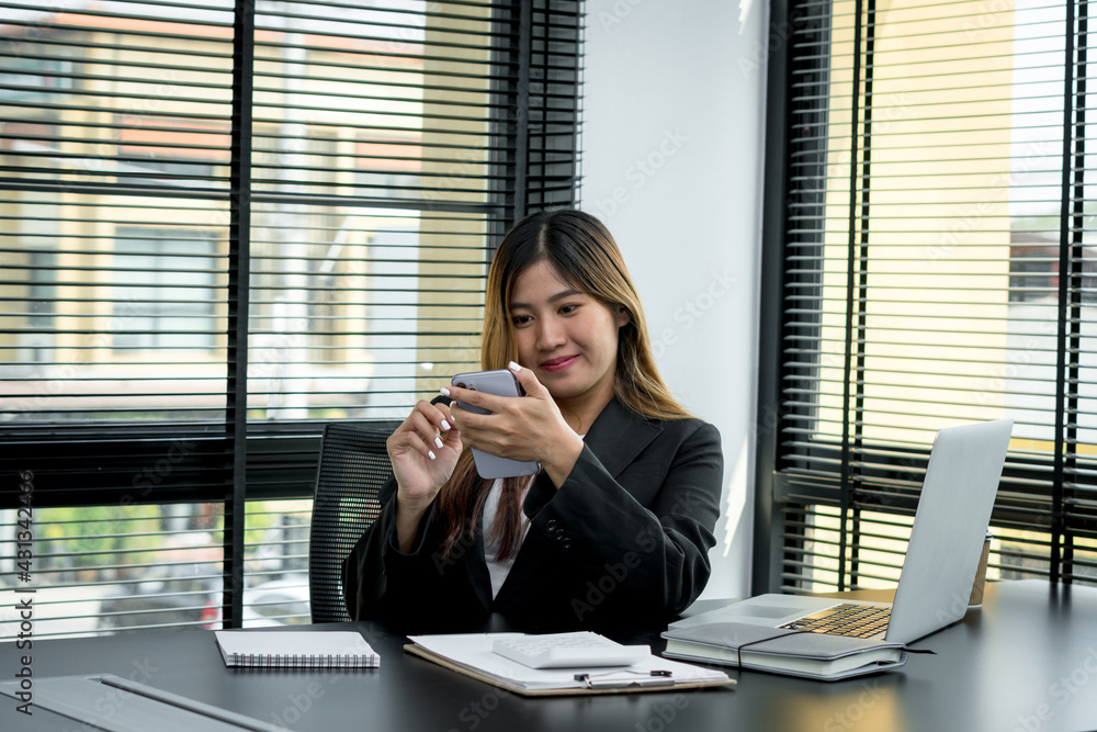 Smiling young manager working on promising project with help of laptop while sitting at modern offic