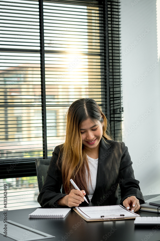 Smiling young manager working on promising project with help of laptop while sitting at modern offic