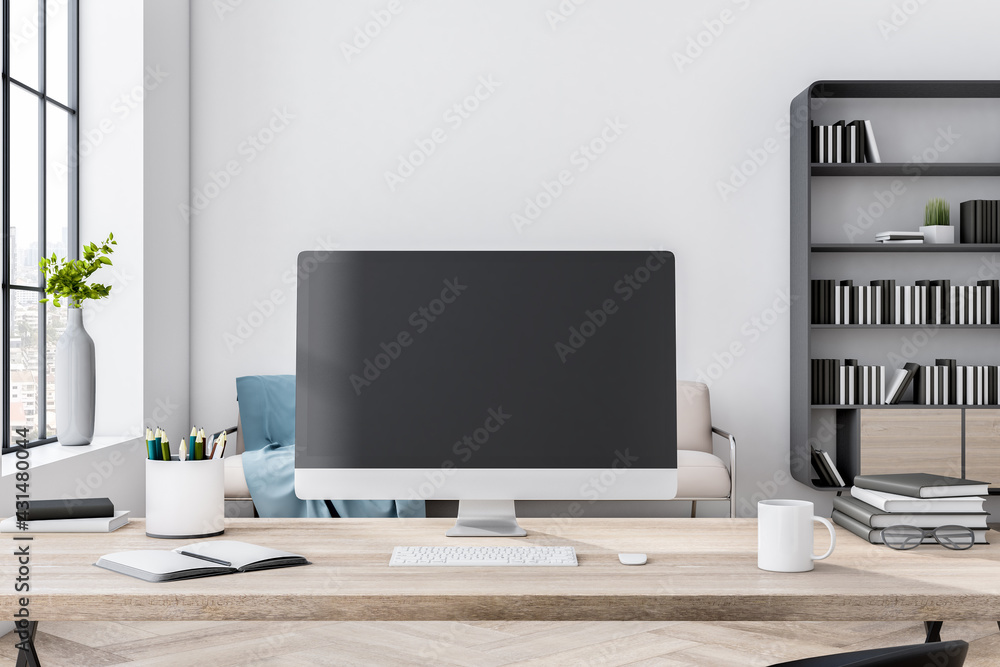 Black computer monitor with copyspace on wooden table in eco style room with light wall, huge window