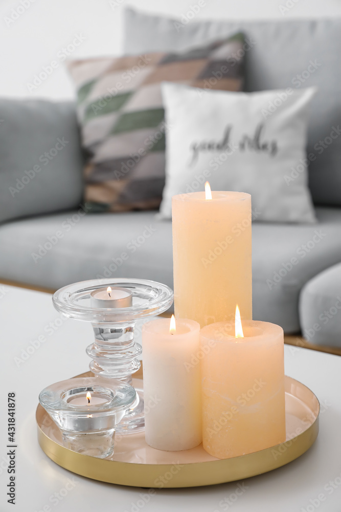 Burning candles on table in living room, closeup