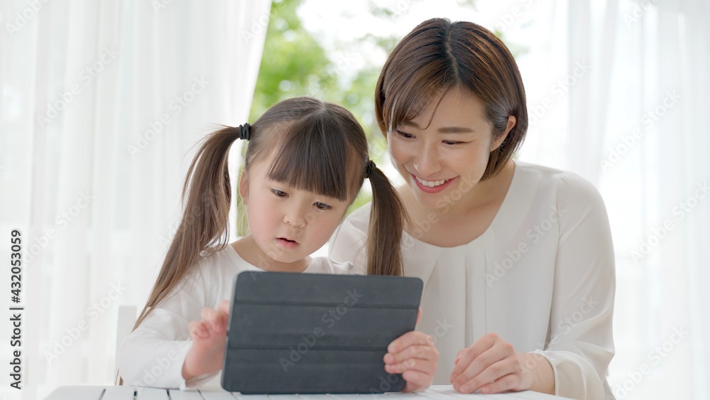 タブレットを使う女の子とお母さん