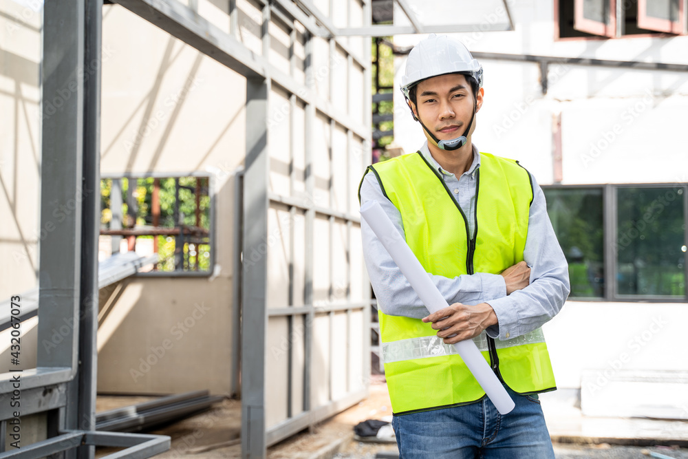 Portrait of Asian male engineer crossing arms, standing at workplace.