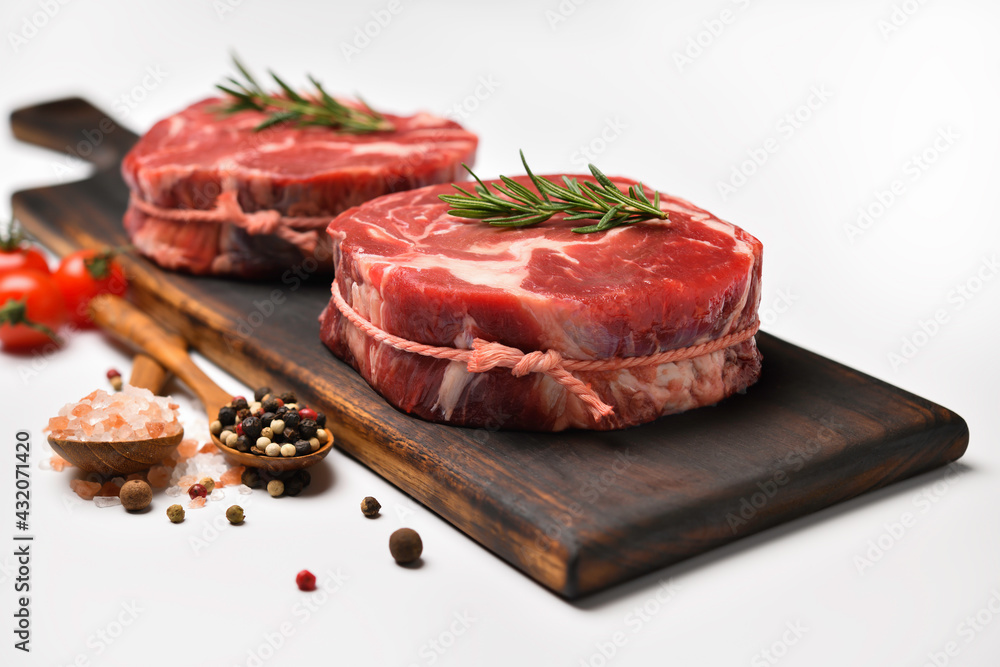 Fresh raw beef meat with ingredients for cooking in the kitchen on white table