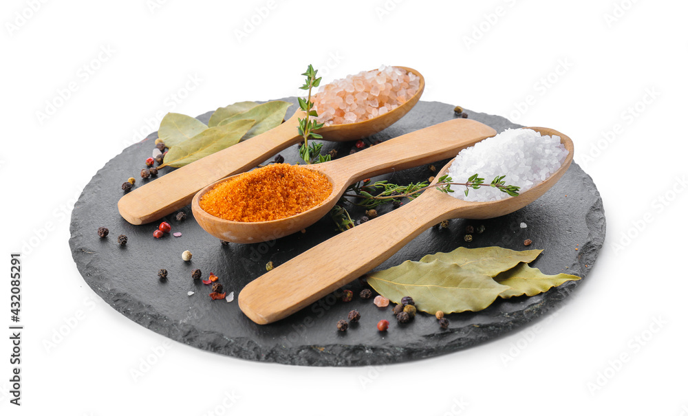 Spoons with different salt and spices on white background