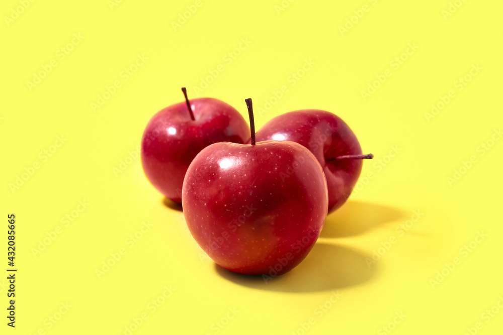 Fresh red apples on color background