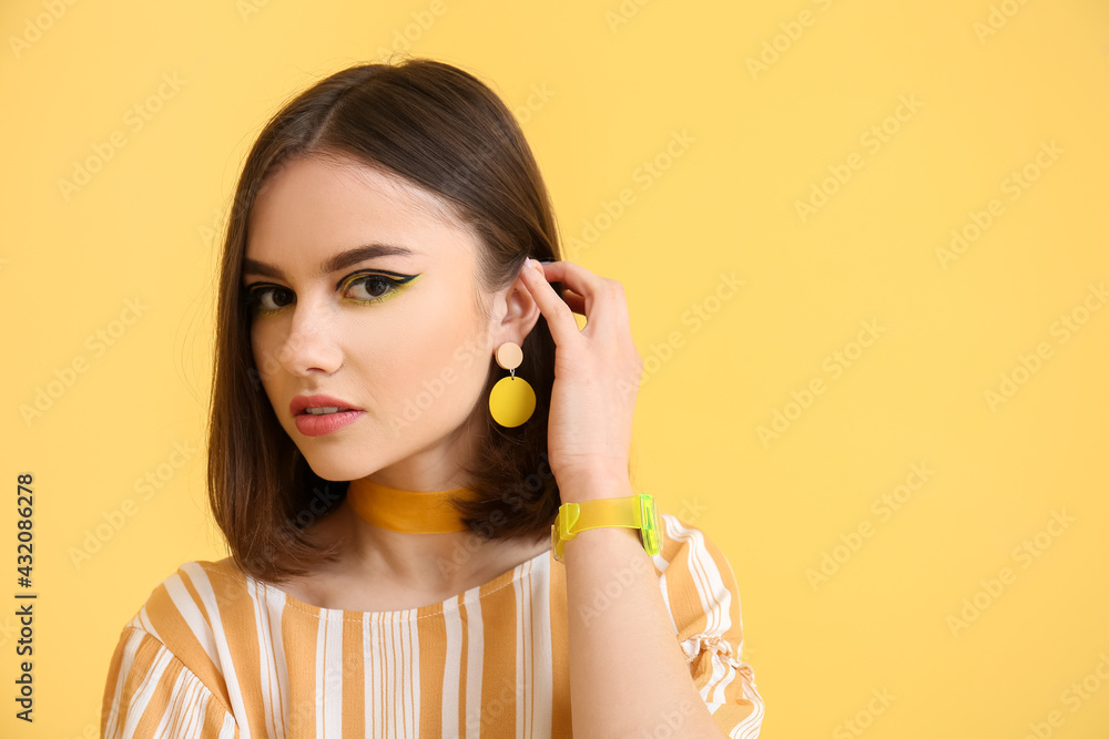 Stylish young woman on yellow background