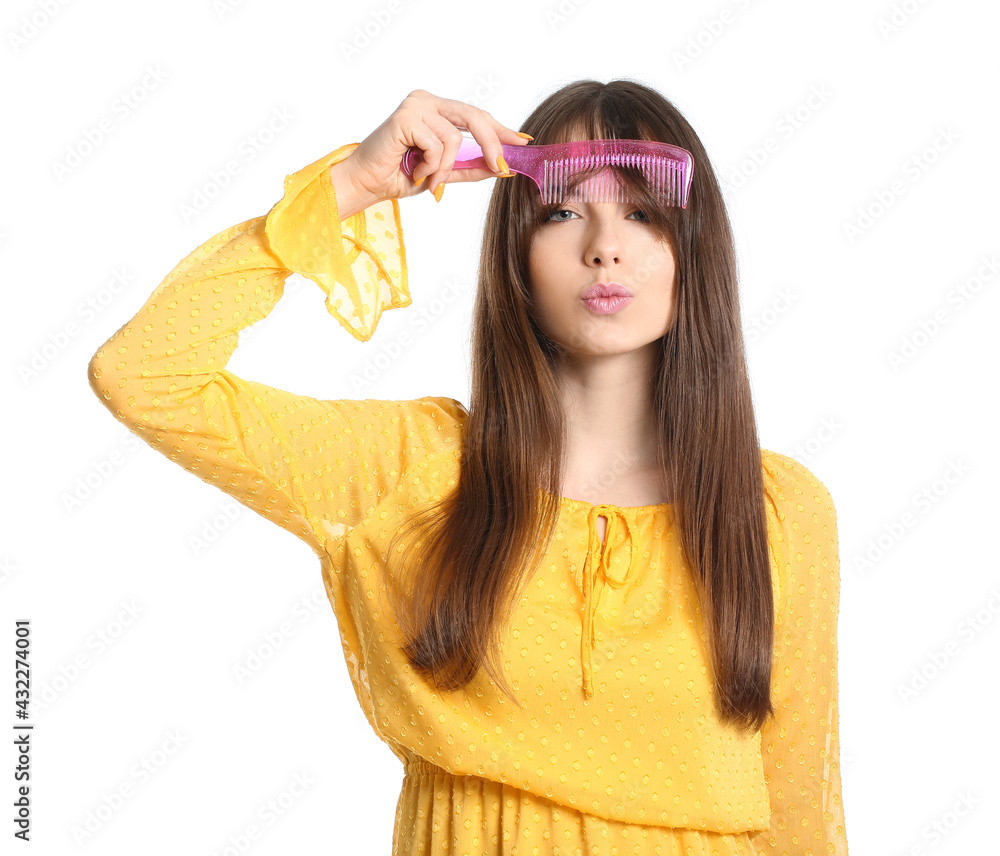 Beautiful young woman with hair comb on white background