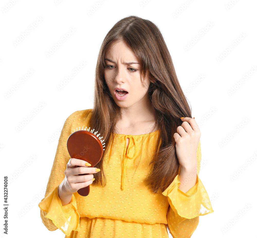 Stressed young woman with hair loss problem on white background