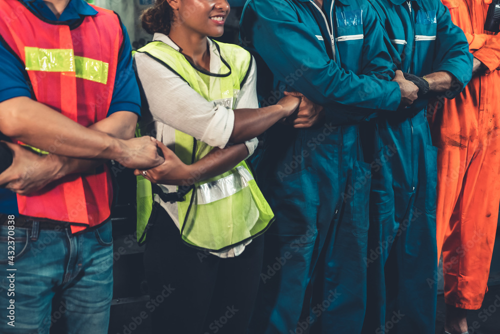 Skillful worker stand together showing teamwork in the factory . Industrial people and manufacturing