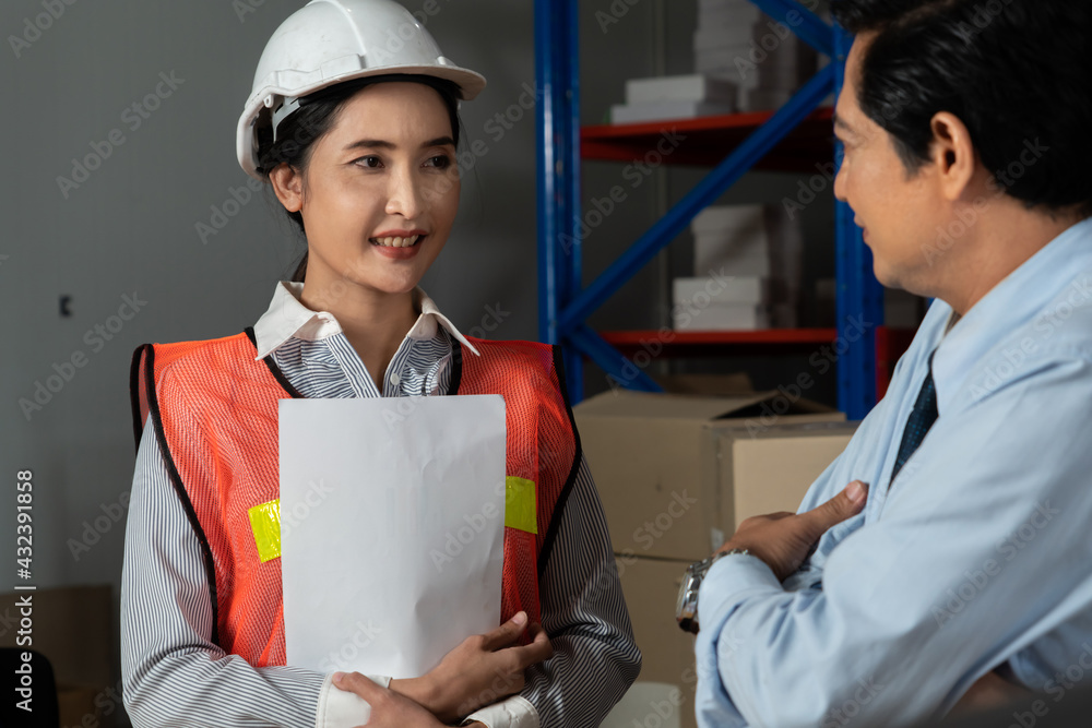 Warehouse manager and worker working in the storehouse . Logistics , supply chain and warehouse busi