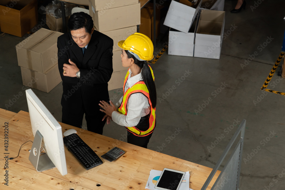 Warehouse manager and worker working in the storehouse . Logistics , supply chain and warehouse busi