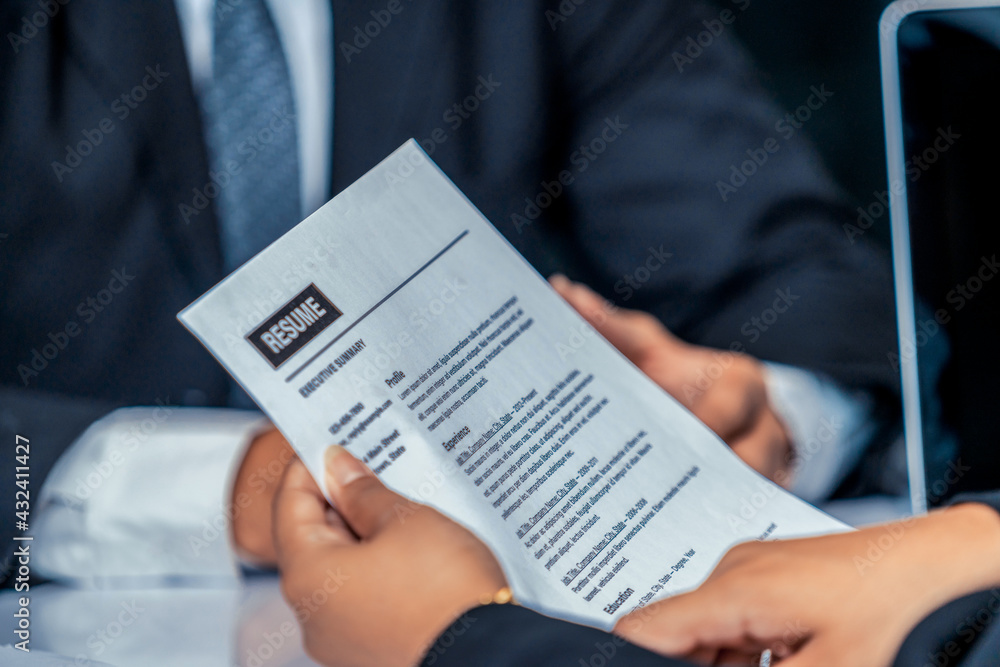 Human resources department manager reads CV resume document of an employee candidate at interview ro