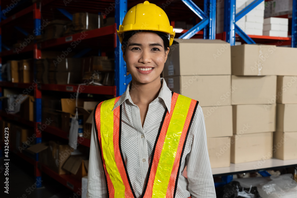 Portrait of young Asian woman warehouse worker smiling in the storehouse . Logistics , supply chain 