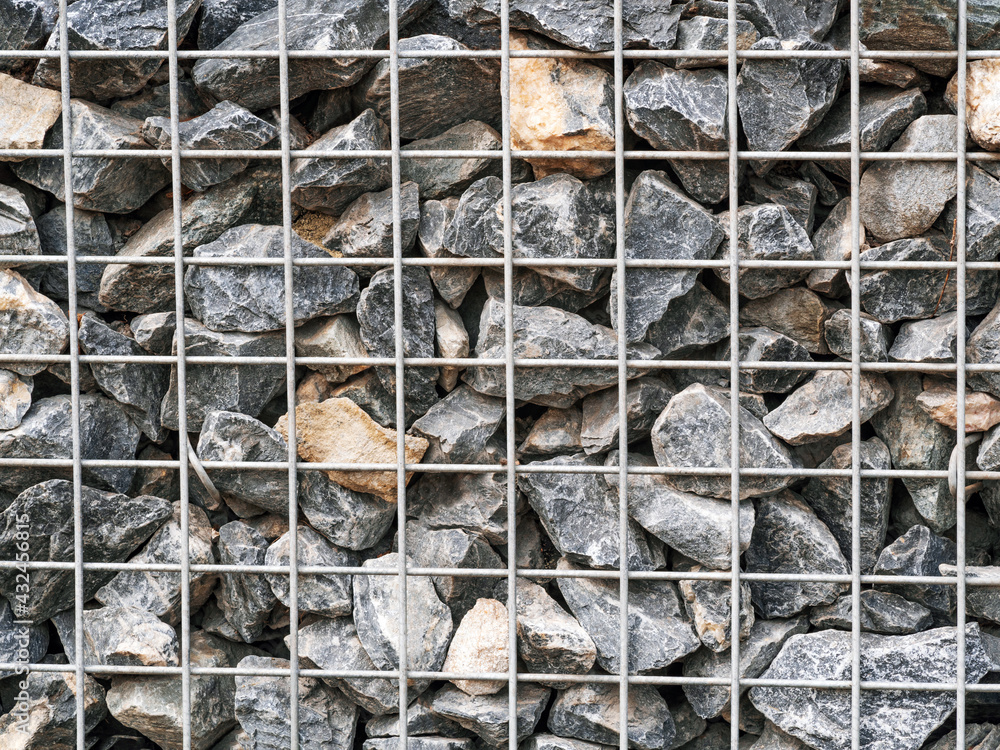 Crushed stone texture under the metal mesh. Stone pattern, close-up.