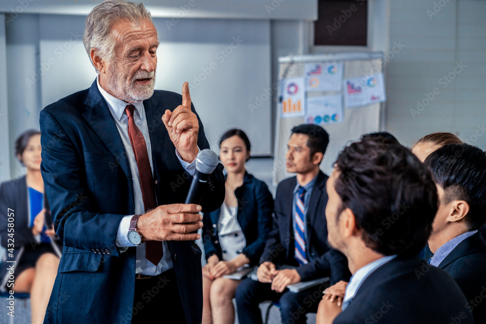 Senior leader speaker speaks to public people audience in training workshop or conference. Mature le