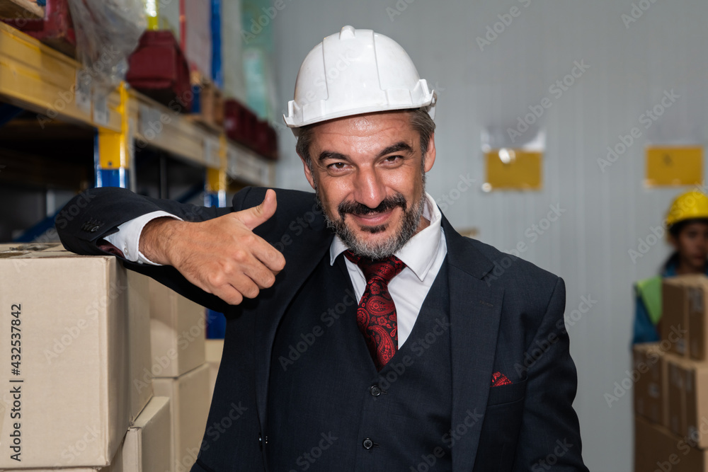 Portrait of happy warehouse manager smiling in the storehouse . Logistics , supply chain and warehou