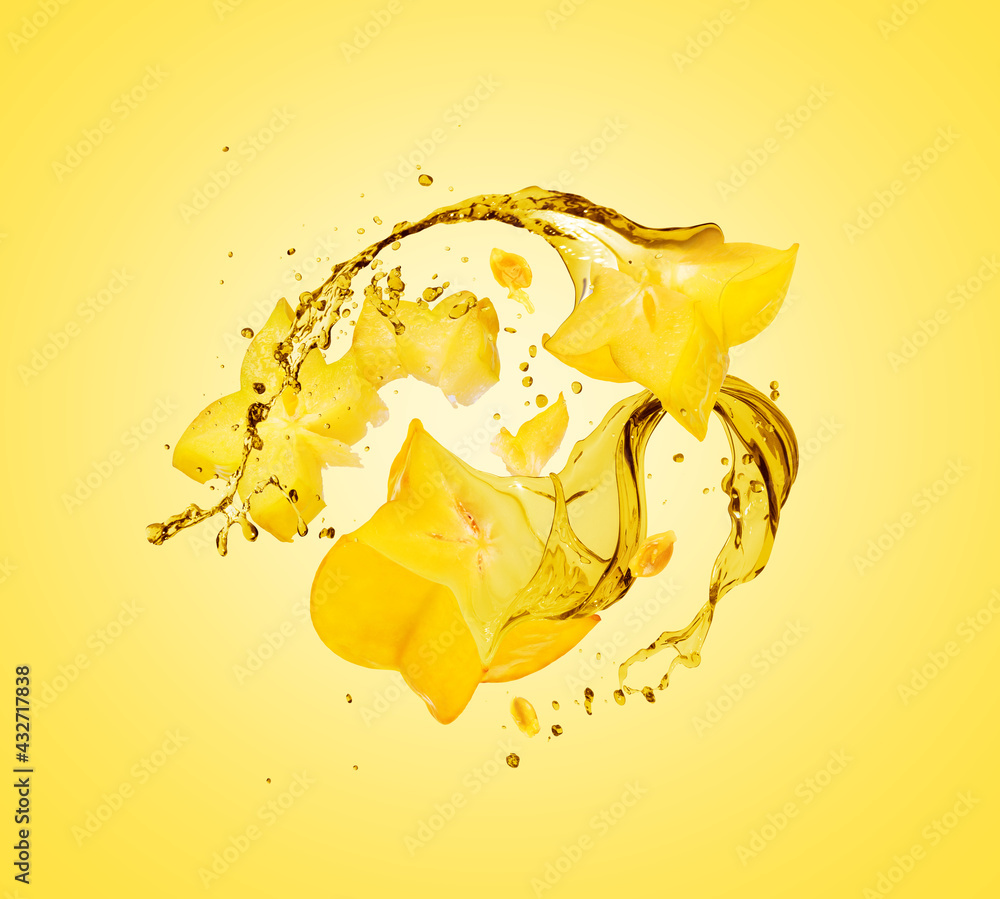 Sliced carambola with splashes of juice close-up on a yellow background