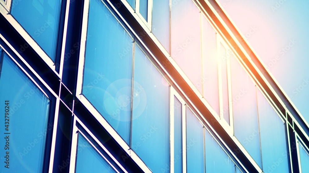 Modern building in the city with sunlight. Abstract texture and blue glass facade in modern office b