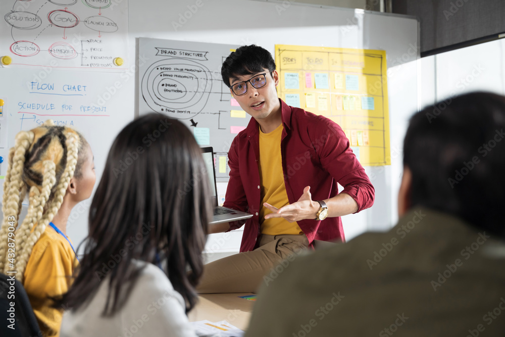 Asian man creative designers present ux ui to team.Designers team working meeting in a modern office