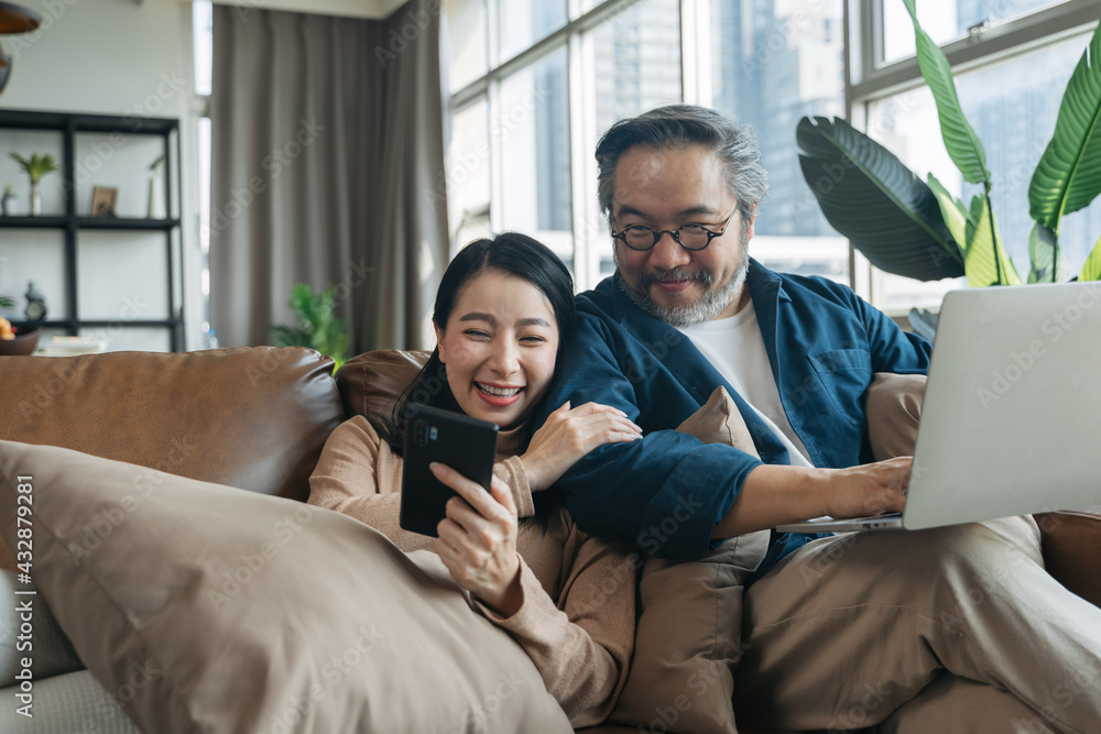 Female showing smartphone to husband in living room at home