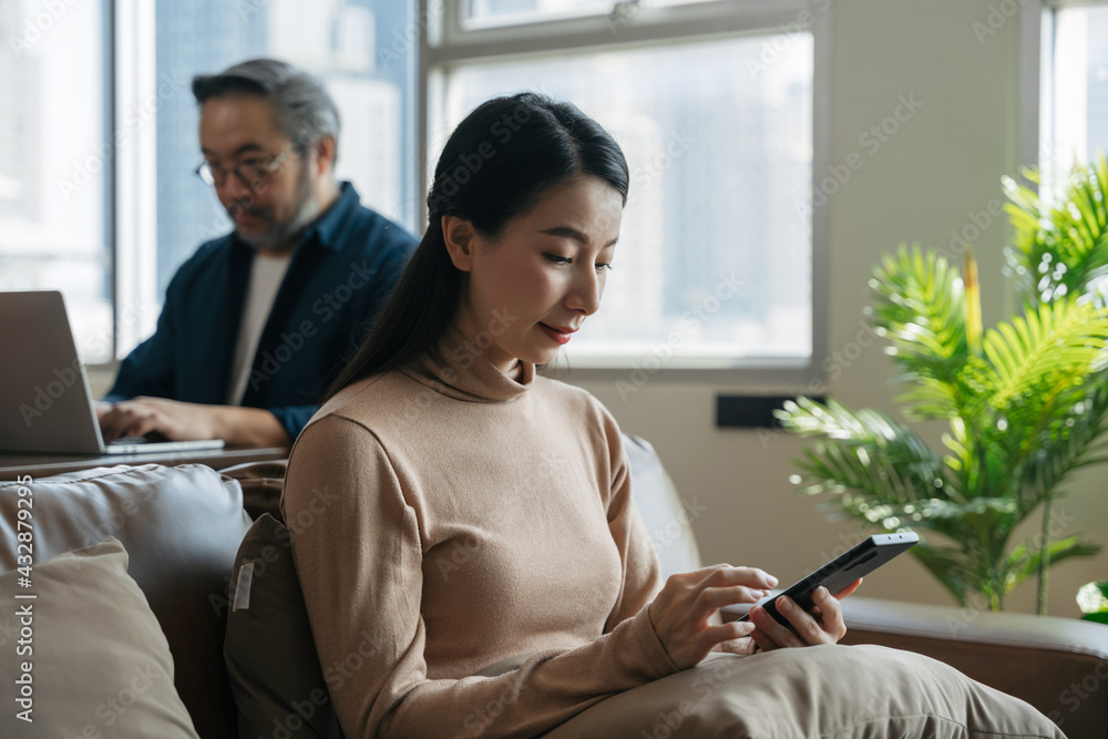 亚洲女性在家使用电话。