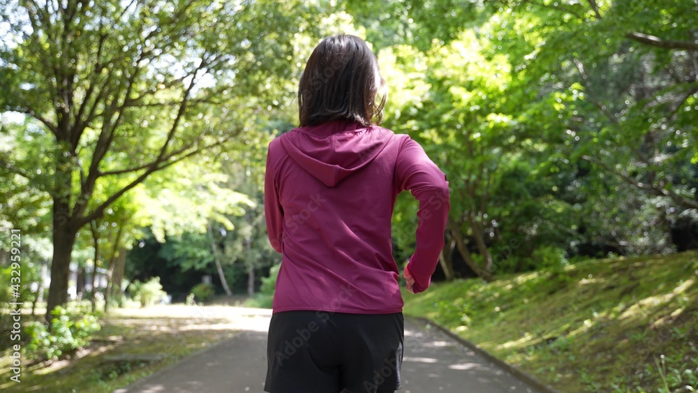 公園でジョギングをする女性