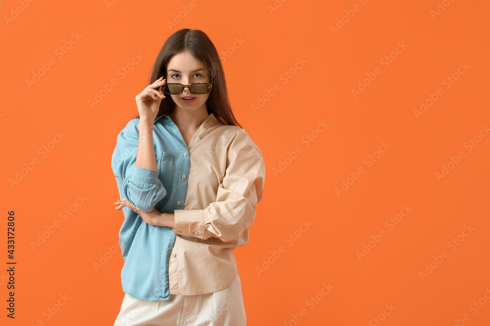 Beautiful young woman with stylish sunglasses on color background