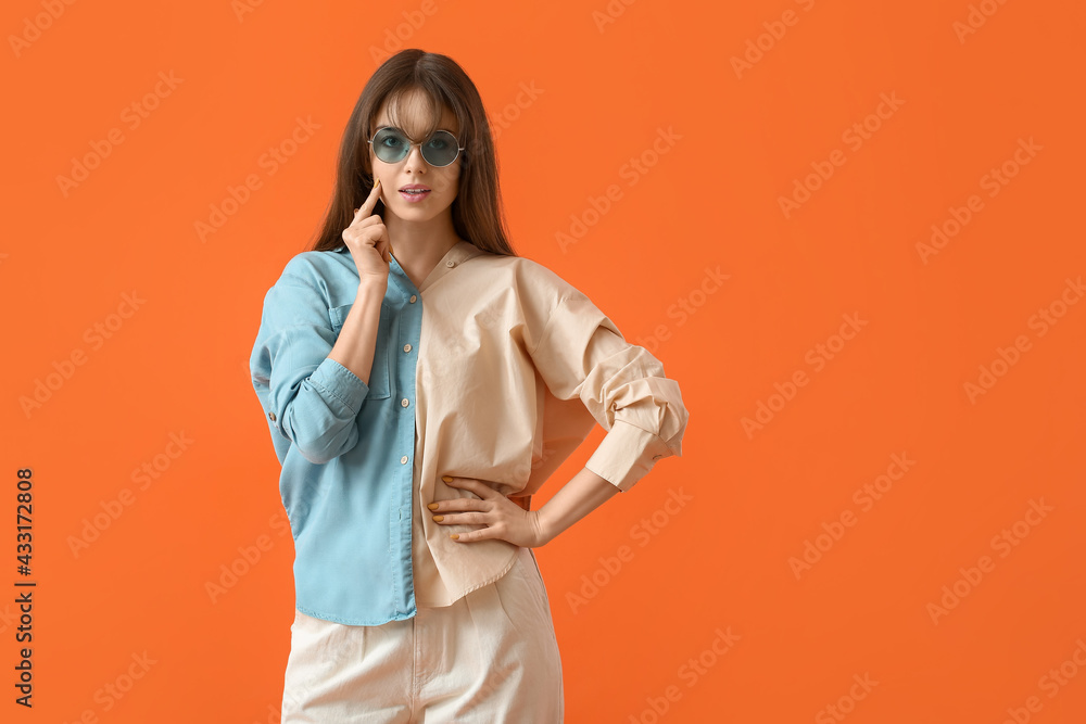 Beautiful young woman with stylish sunglasses on color background