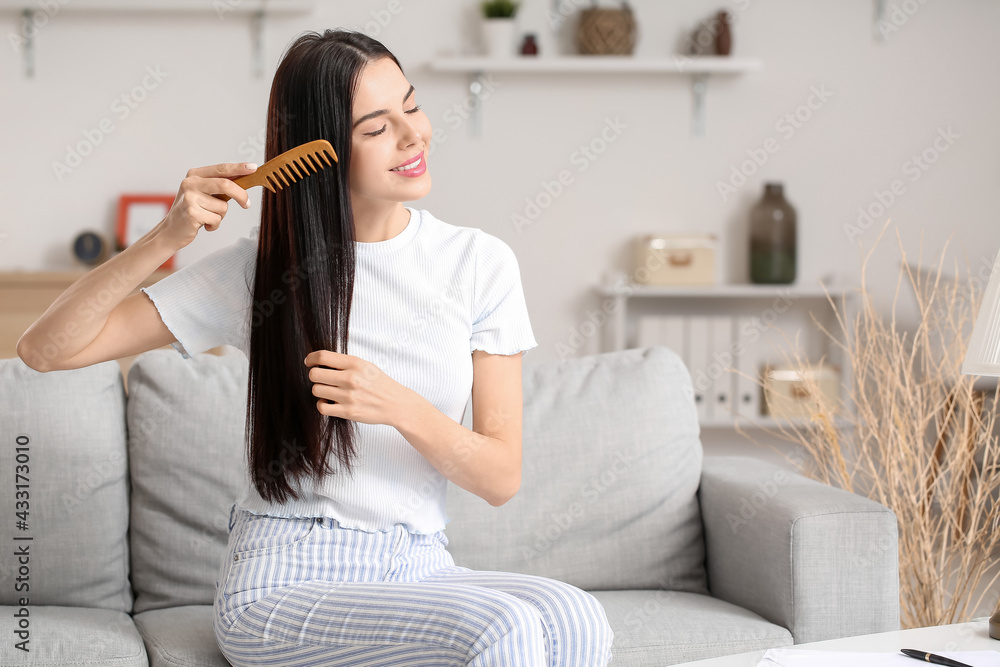 美丽的年轻女子在家梳头