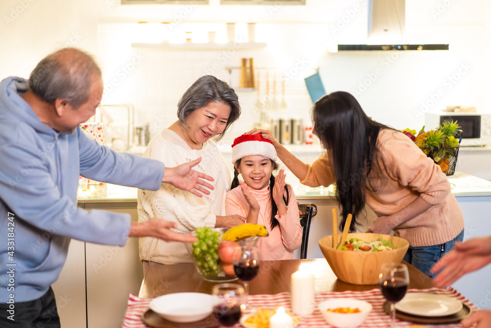 亚洲大家庭在为圣诞派对准备食物时唱歌