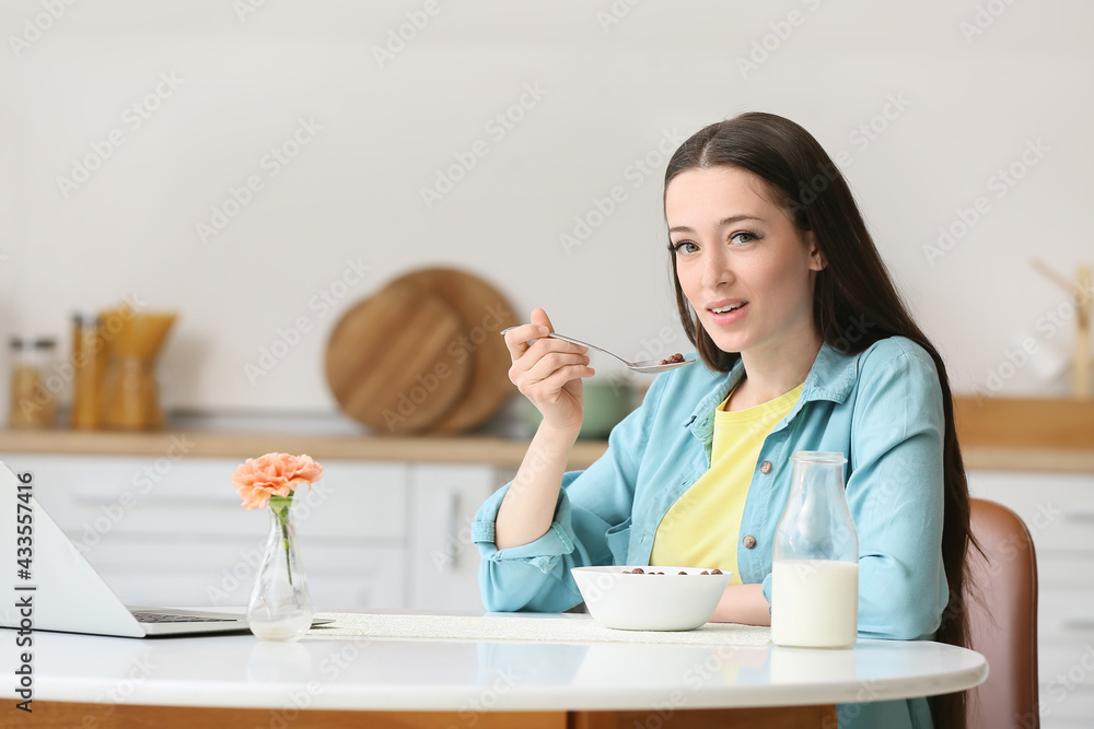 Young woman having breakfast at home