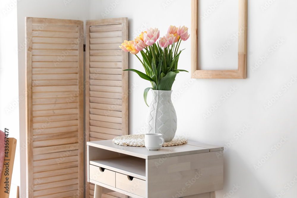 Bouquet of beautiful tulip flowers on table near white wall